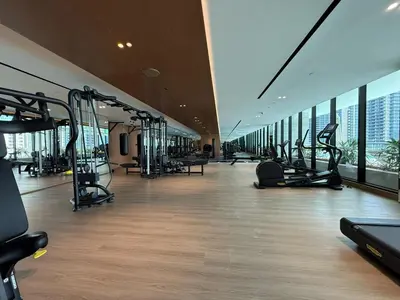 a gym with cardio equipment in a building with windows at Daniels Studio at Marasi Drive with Canal View in Dubai