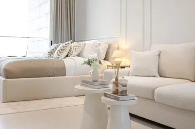 a white living room with a bed and a couch at Daniels Studio at Marasi Drive with Canal View in Dubai