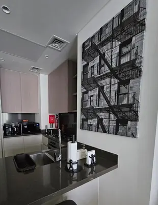 a kitchen with a sink and a painting on the wall at Luxury Fully Furnished One Bedroom in Dubai