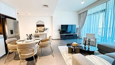 a living room with a couch and a table with chairs at Luxury 2BHK & Lagoon view in Dubai