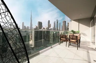 a balcony with two chairs and a table and a view of the city at Burj Khalifa View - 4 min Dubai Mall - SwimingPool - Business Bay in Dubai