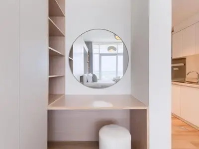 a bathroom with a round mirror and a stool at TRPS - Carson Tower B, DAMAC Hills - Brand New Luxury Studio Apartment in Dubai