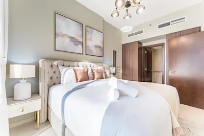 a bedroom with a white bed and a brown door at City and Burj Khalifa View 2BR, Near Dubai Water Canal, Vera Tower, Business Bay by Deluxe Holiday Homes in Dubai