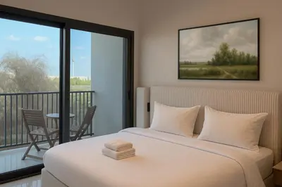 a bedroom with a bed and a balcony with a table at Sleek New Studio in Meydan, Fully Equipped and Spacious in Dubai