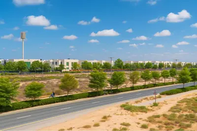 an empty road with trees and buildings in the background at Sleek New Studio in Meydan, Fully Equipped and Spacious in Dubai