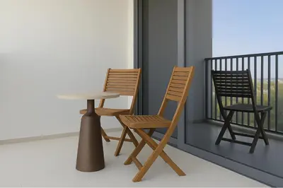 two chairs and a table and two chairs on a balcony at Sleek New Studio in Meydan, Fully Equipped and Spacious in Dubai