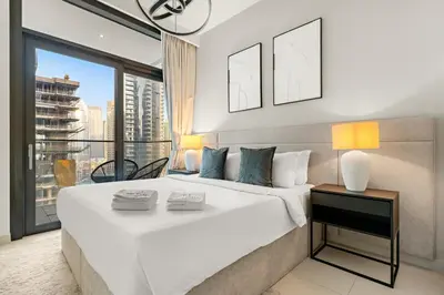 a bedroom with a large white bed and a large window at Luxury 3BR Downtown Apt with Burj Khalifa, Dubai Mall & Opera House Views in Dubai