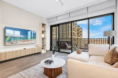 a living room with a couch and a large window at Family 2BR Near Creek, Shops, Dining & Top Attractions in Dubai