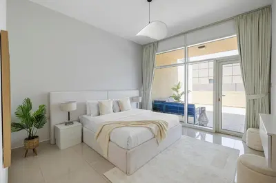 a white bedroom with a bed and a large window at 1BR plus Extra Bedroom Bay Square B7, City View in Dubai