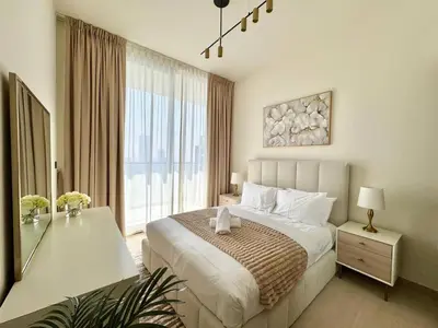 a bedroom with a large bed and a large window at Cozy 1br With Elegant Interiors! in Dubai