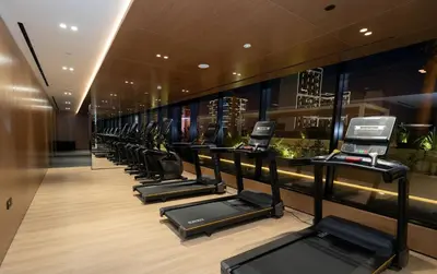 a row of treadmills in a gym with a row at Cozy 1br With Elegant Interiors! in Dubai