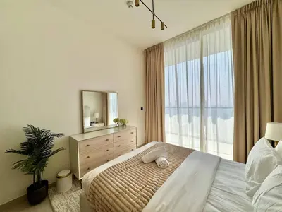 a bedroom with a bed with a mirror and a dresser at Cozy 1br With Elegant Interiors! in Dubai