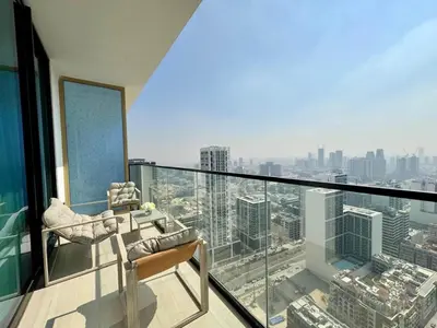 a balcony with a chair and a view of a city at Cozy 1br With Elegant Interiors! in Dubai