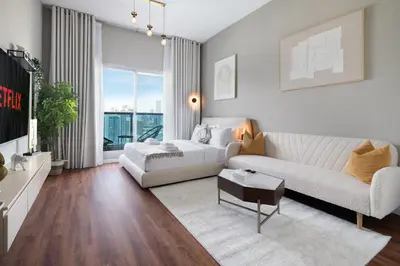 a living room with a bed and a couch at Studio Aura at Dubai Sports City in Dubai