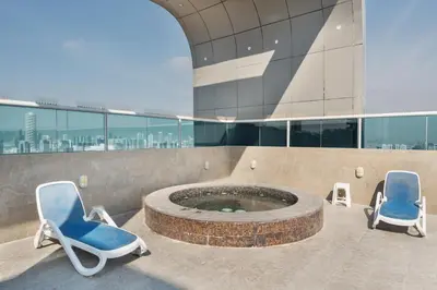 two chairs and a hot tub in a building at Studio Aura at Dubai Sports City in Dubai