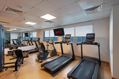 a gym with treadmills and elliptical machines at Studio Aura at Dubai Sports City in Dubai