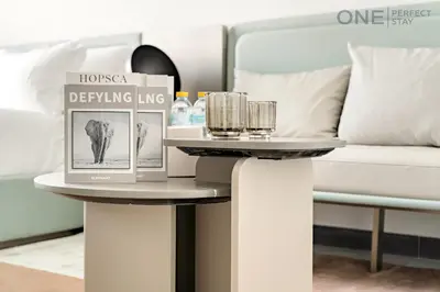 a table with a book on it next to a bed at Modern Cozy Studio in Dubai
