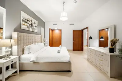 a bedroom with a large white bed and a sink at FIRST CLASS 1BR Majestic Burj Khalifa View in Dubai