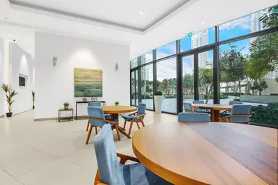 a dining room with tables and chairs and large windows at FIRST CLASS 1BR Majestic Burj Khalifa View in Dubai