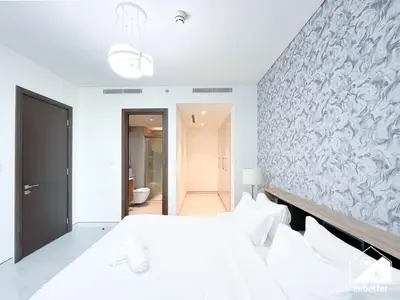 a bedroom with a white bed and a wall at Stunning 2-Bed Home in Sobha Creek Vistas in Dubai