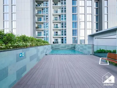 a swimming pool with a bench and a building at Stunning 2-Bed Home in Sobha Creek Vistas in Dubai
