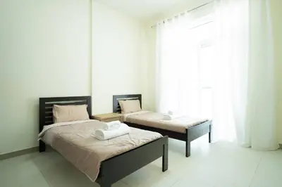 a bedroom with two beds and a window at 2BR Spacious Pearl with Stunning City Views - Holiday Boulevard in Dubai