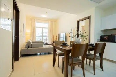 a kitchen and living room with a table and chairs at 2BR Spacious Pearl with Stunning City Views - Holiday Boulevard in Dubai