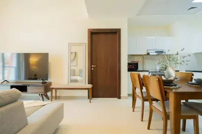 a kitchen and living room with a table and chairs at 2BR Spacious Pearl with Stunning City Views - Holiday Boulevard in Dubai