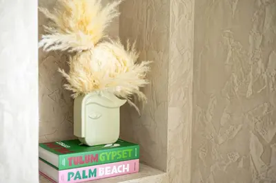 a vase filled with feathers sitting on top of books at 41st-Floor 2BR with World's Highest Running Track in Dubai