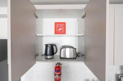 a kitchen with a coffee maker and a tea kettle at 41st-Floor 2BR with World's Highest Running Track in Dubai