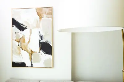 a white lamp in a living room with a painting at Onyx 1BR with Stunning City Views in Dubai