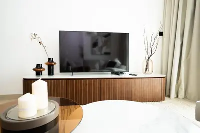a living room with a tv and a glass table at Onyx 1BR with Stunning City Views in Dubai