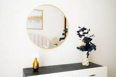 a mirror on top of a table with a vase at Onyx 1BR with Stunning City Views in Dubai