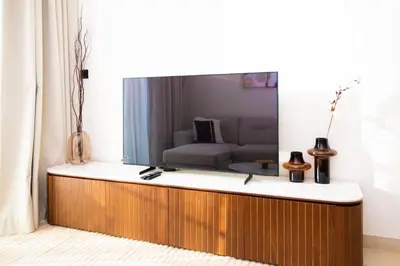 a living room with a flat screen tv on a wall at Luxury 1BR on High Floor JVC in Dubai