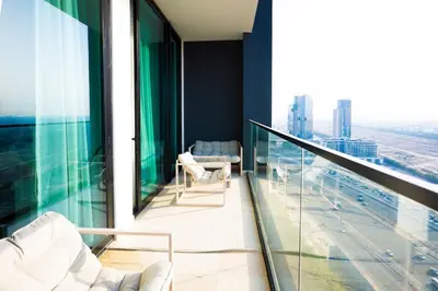 a balcony with chairs and a view of a city at Luxury 1BR on High Floor JVC in Dubai