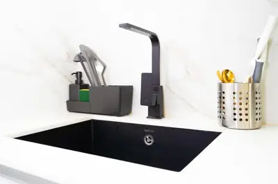 a kitchen counter with a sink and a faucet at Luxury 1BR on High Floor JVC in Dubai