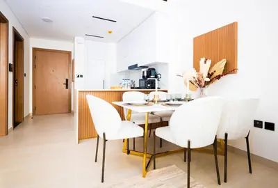 a kitchen and dining room with a table and chairs at Elegant 1BR with High Rise JVC in Dubai