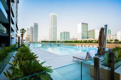 a swimming pool with a city skyline in the background at Elegant 1BR with High Rise JVC in Dubai