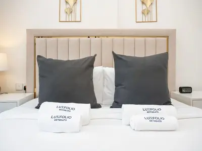 a bedroom with a white bed with two pillows at Bright and Spacious 1 Bed Prime JVC Location in Dubai