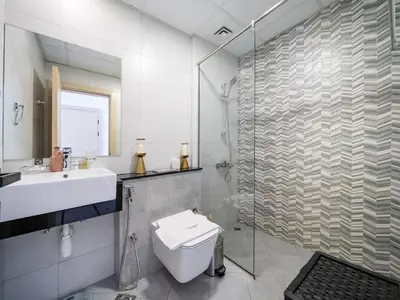 a bathroom with a shower and a toilet and a sink at Bright and Spacious 1 Bed Prime JVC Location in Dubai