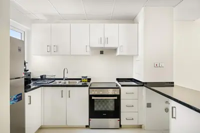 a kitchen with white cabinets and a stove top oven at Tranquil 3BR Villa with Malibu Beach Access in Dubai
