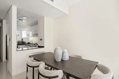 a dining room with a wooden table and chairs at Tranquil 3BR Villa with Malibu Beach Access in Dubai