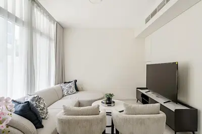 a living room with a couch and chairs and a tv at Tranquil 3BR Villa with Malibu Beach Access in Dubai