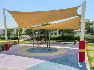 a playground in a park with a yellow canopy at Tranquil 3BR Villa with Malibu Beach Access in Dubai