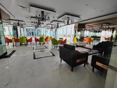 a restaurant with chairs and tables in a room at Modern Studio with free Netflix - Close to Metro in Dubai