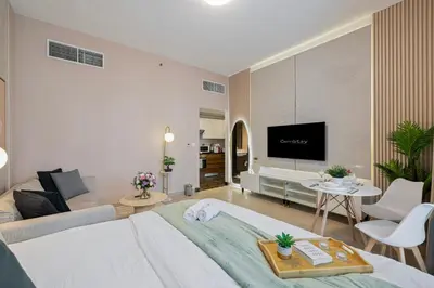 a bedroom with a bed and a living room at Charming Studio Retreat -Few steps away from Ocean in Dubai