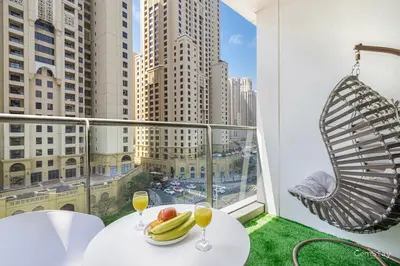 a balcony with a table with fruit and wine glasses at Charming Studio Retreat -Few steps away from Ocean in Dubai