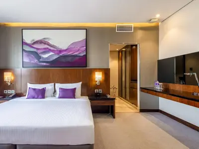 a hotel room with a bed and a tv at Flora Al Barsha Hotel At The Mall in Dubai
