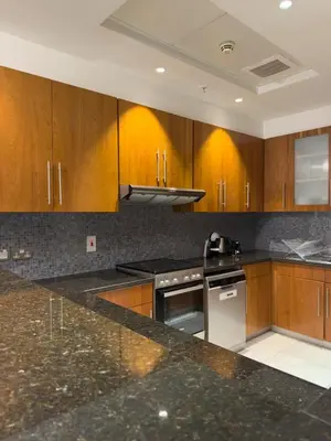 a kitchen with wooden cabinets and a black counter top at Nasma Luxury stays - Executive stay in the Heart of Dubai Financial Hub in Dubai