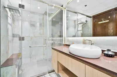 a bathroom with a sink and a glass shower at Stylish 2BR with Pool, Gym, Sauna & Kid's Playground in Dubai